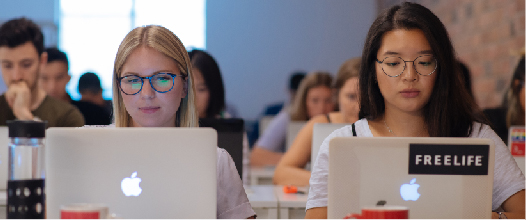  Students in classroom in front of laptop